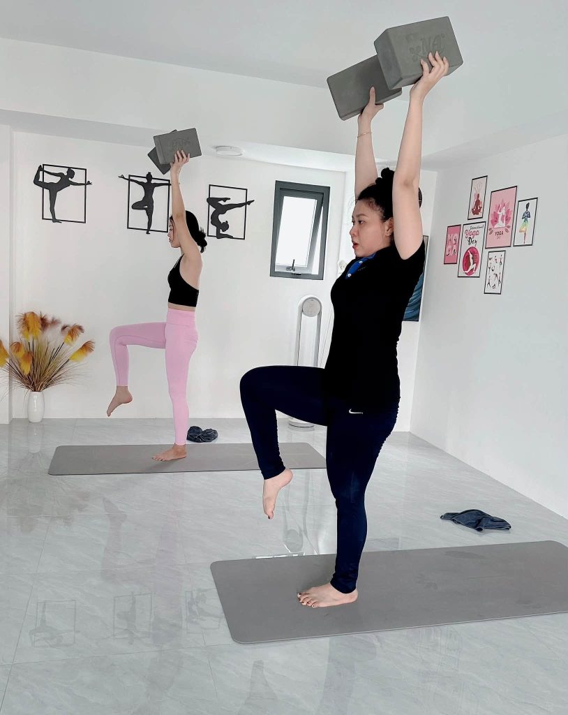 Kỹ thuật yoga đứng một chân nâng gạch lên cao rèn sức mạnh và sự tập trung