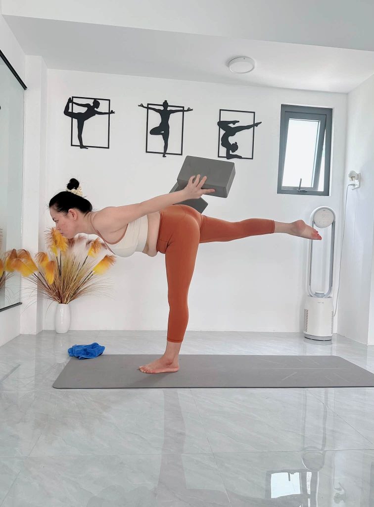 Tư thế nửa vầng trăng với gạch tập giúp giữ thăng bằng đúng kỹ thuật yoga