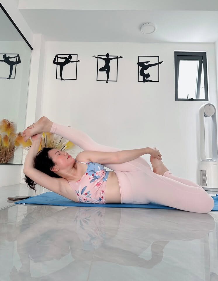 Tư thế nằm nghiêng nắm chân kéo giãn sâu tại Yoga Phương Ruby