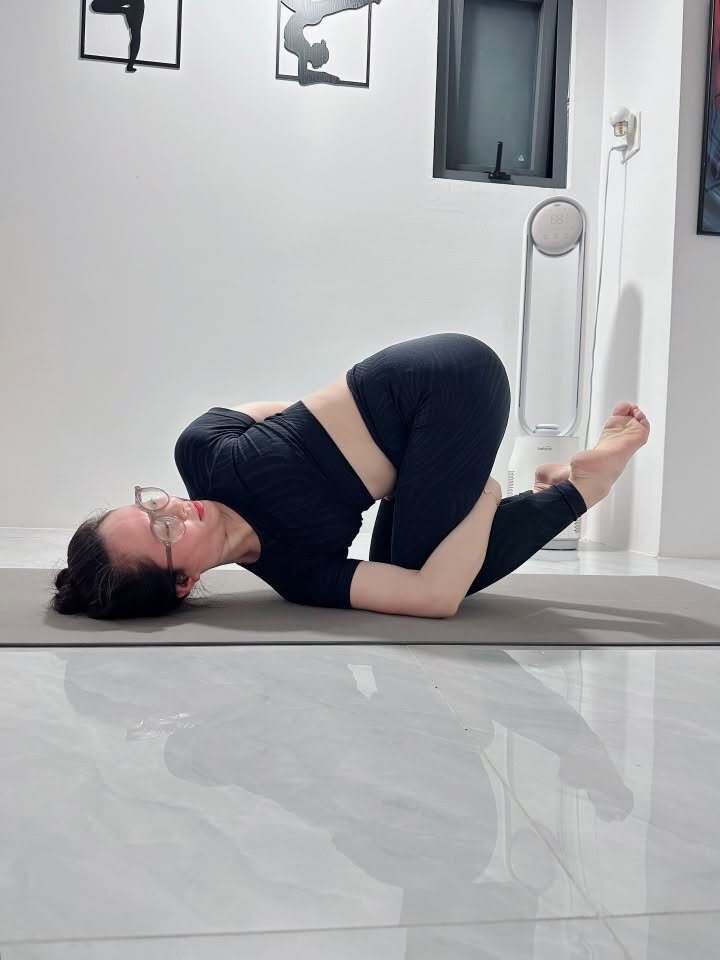 Tư thế nằm ôm gối giúp giảm căng lưng dưới trong yoga trị liệu Cần Thơ